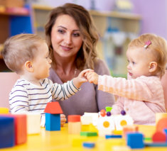 Little caucasian babies playing with Montessori toy